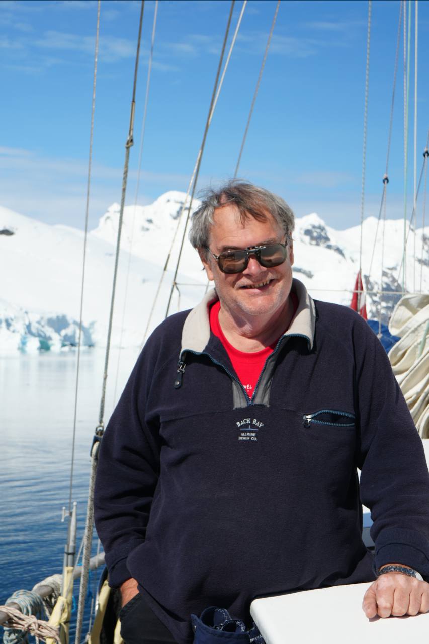 Igor Mironenko on deck in Antarctica: sunglasses, fleece, ice and a blue sky behind.
